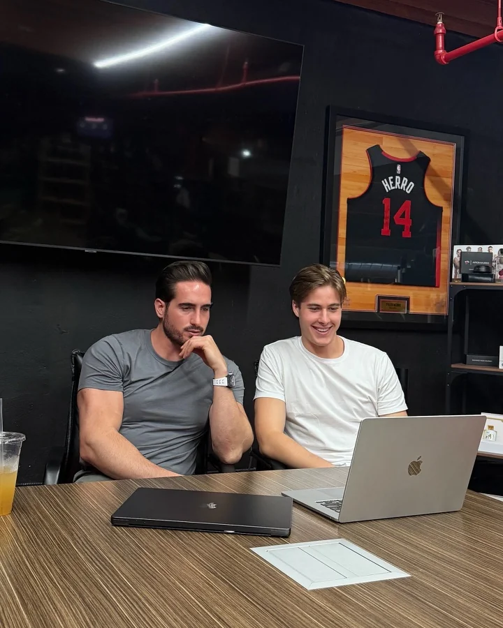 Remy and Hudson working together at a table with laptops.